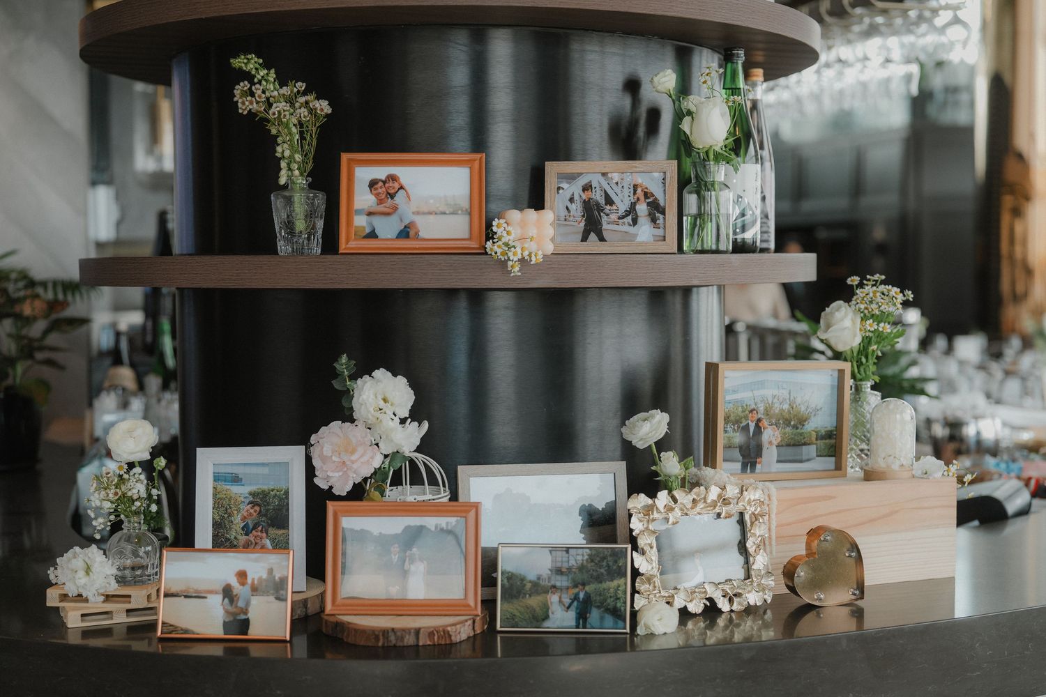 Wedding reception details including floral arrangements and photo displays on rustic wooden tables.