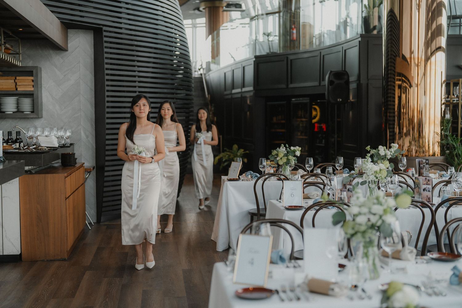 Wedding reception setup in a modern venue with bentwood chairs and elegant table decorations.