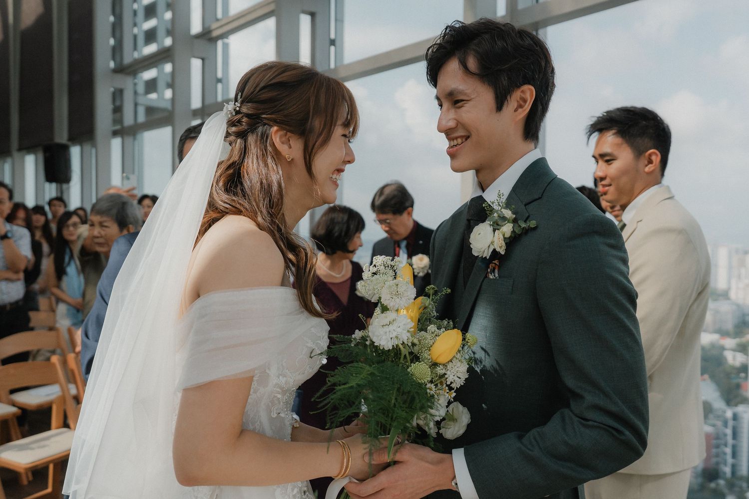 Wedding celebration in a modern glass-walled venue with city views.