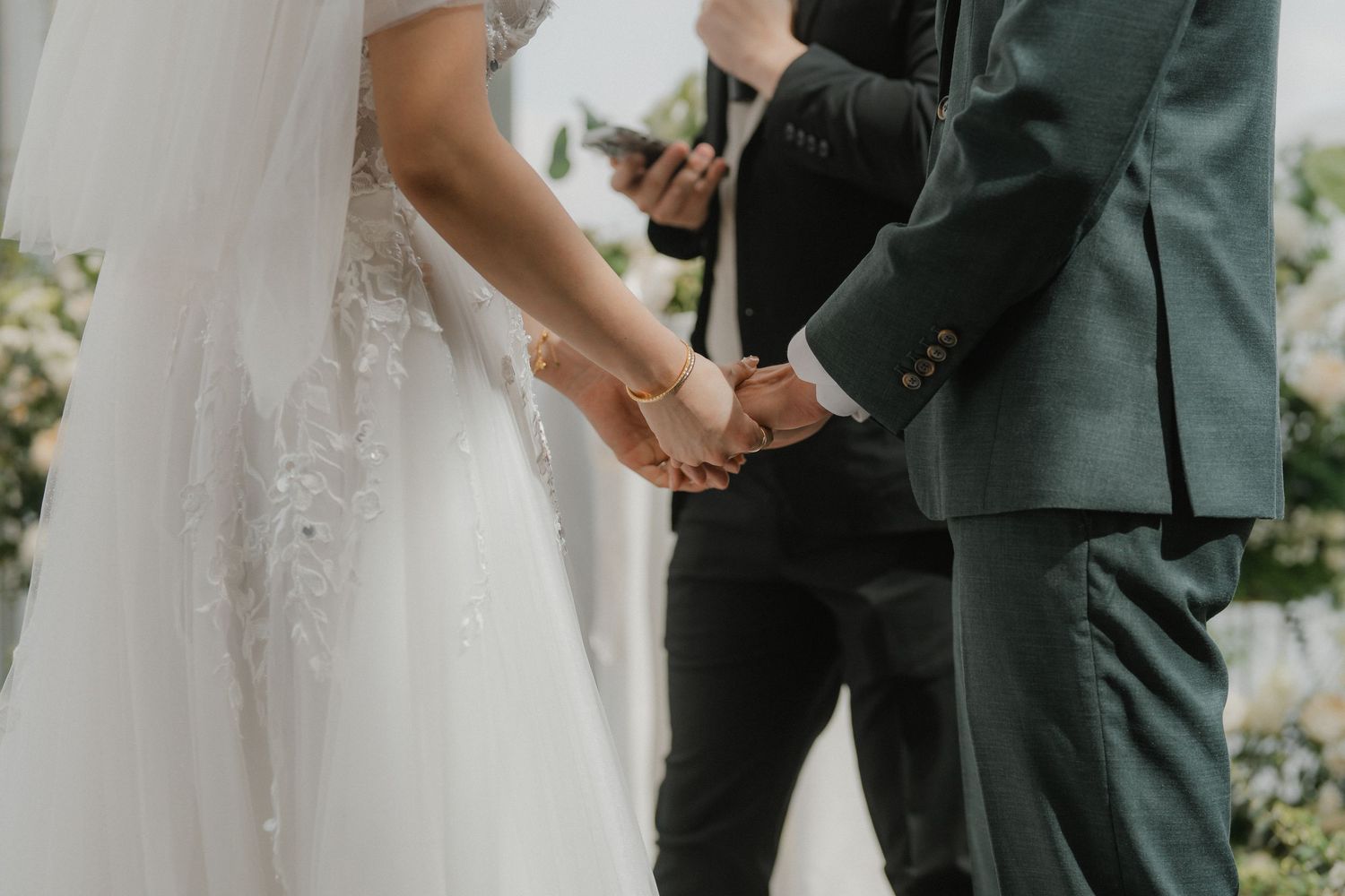 A bride in white dress and groom in dark suit share an intimate moment during their wedding ceremony.