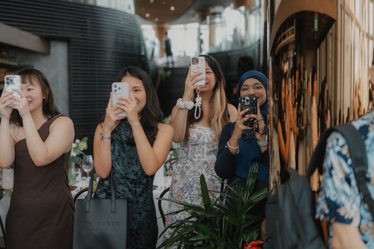 Group of guests taking photos with their phones during an event.