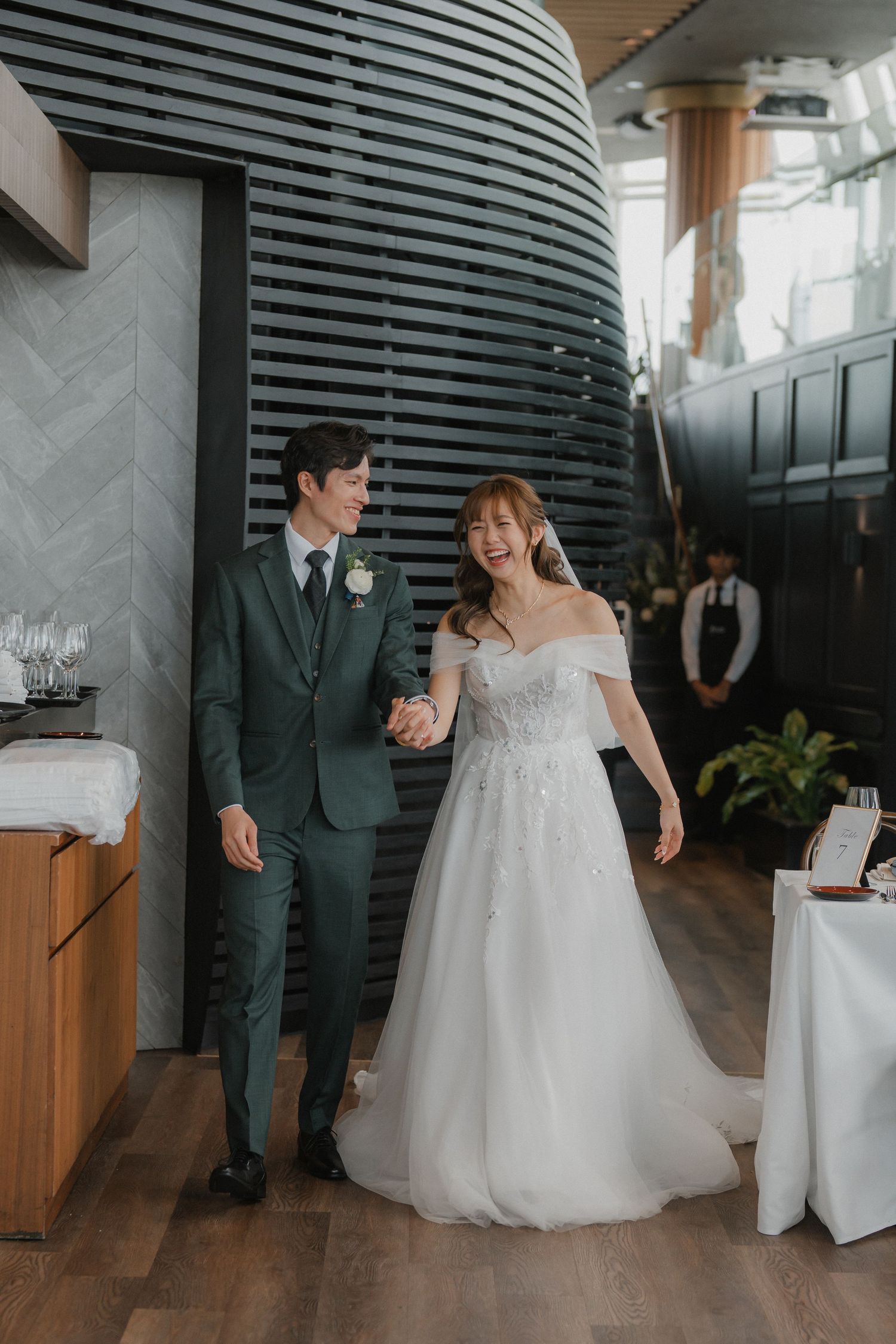 Wedding celebration in a modern venue with sleek black walls and wooden flooring.