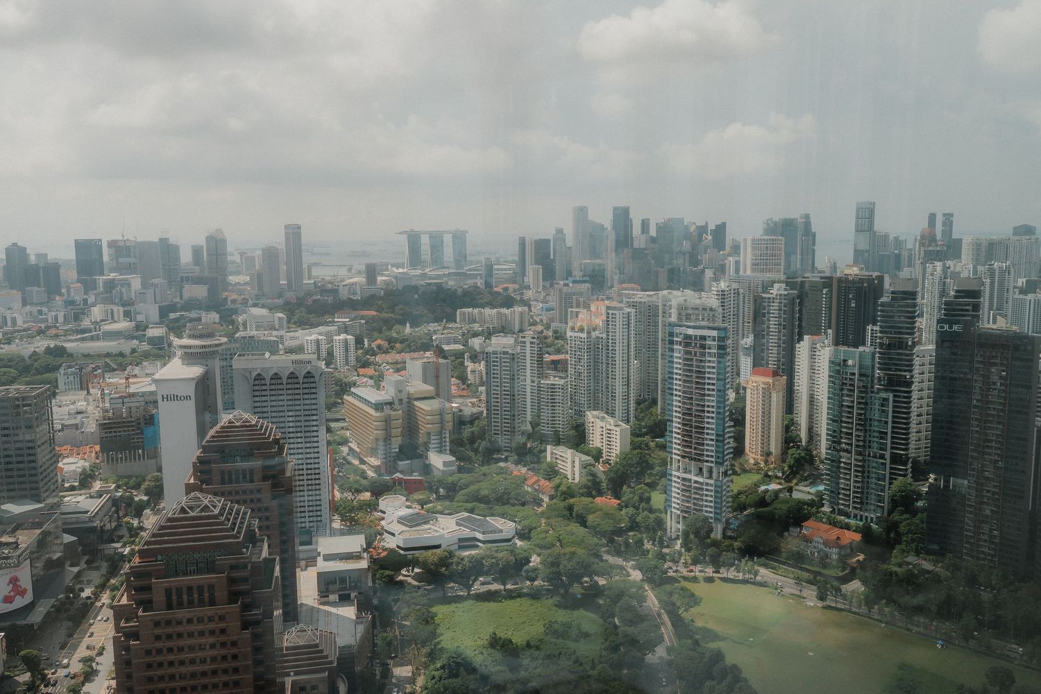 Aerial view of Singapore's downtown skyline showing modern skyscrapers and urban parks.
