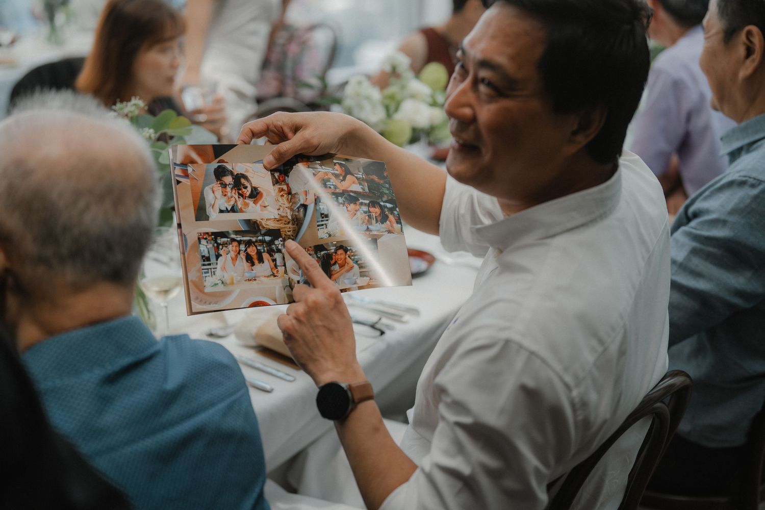 Guests seated at reception tables enjoying conversations and festivities during a wedding celebration.