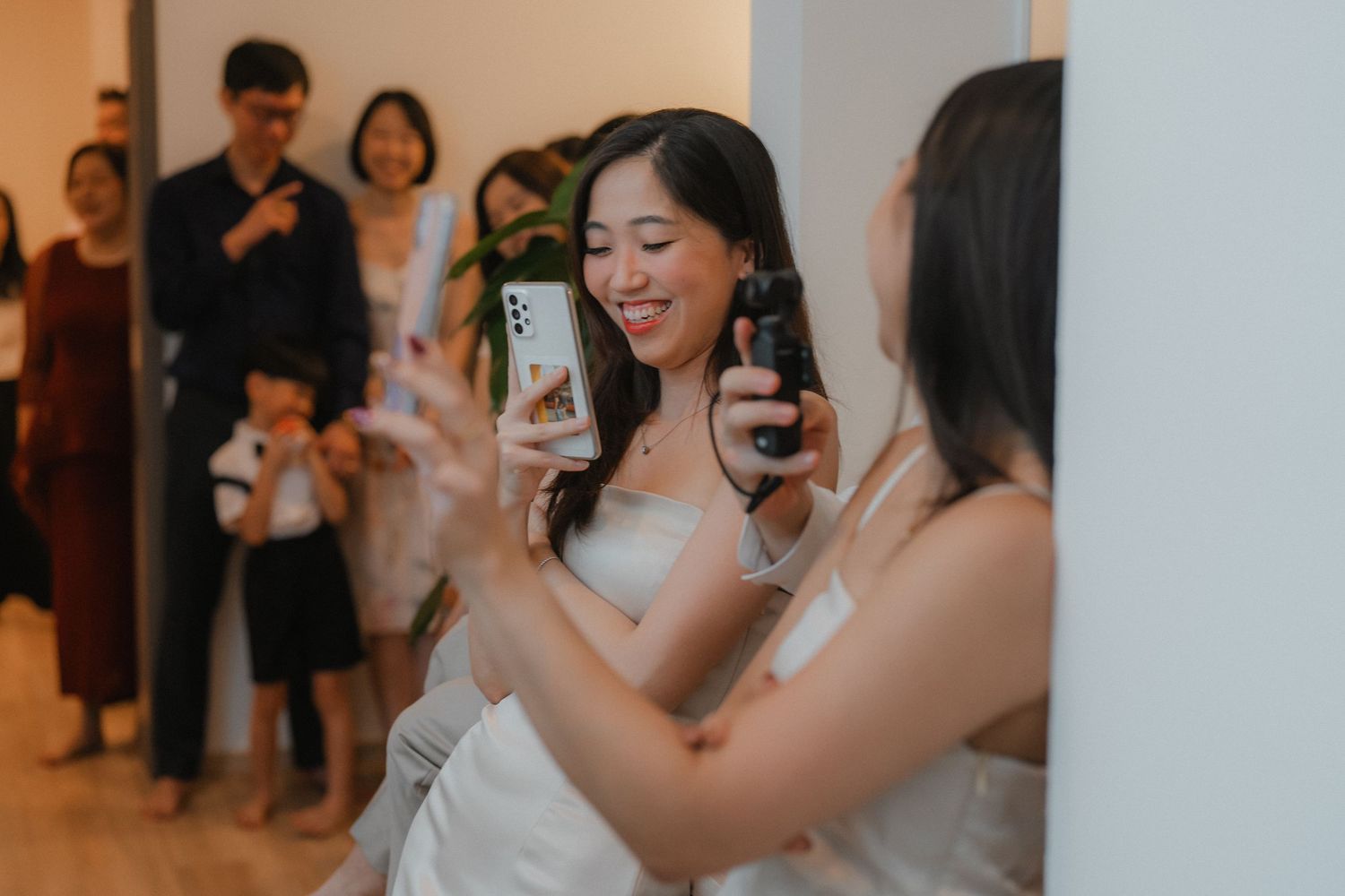 Wedding guests taking photos and sharing moments during an indoor celebration.