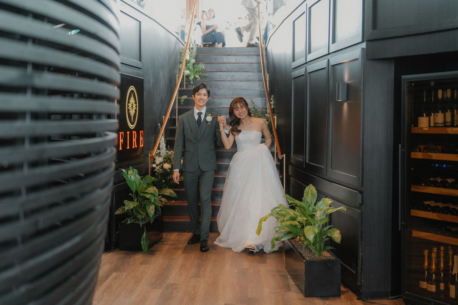 Wedding couple walking through modern industrial-style hallway with dark walls.