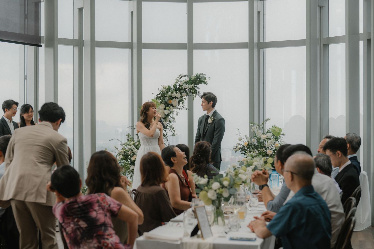 Elegant wedding venue with floor-to-ceiling windows overlooking a cityscape.