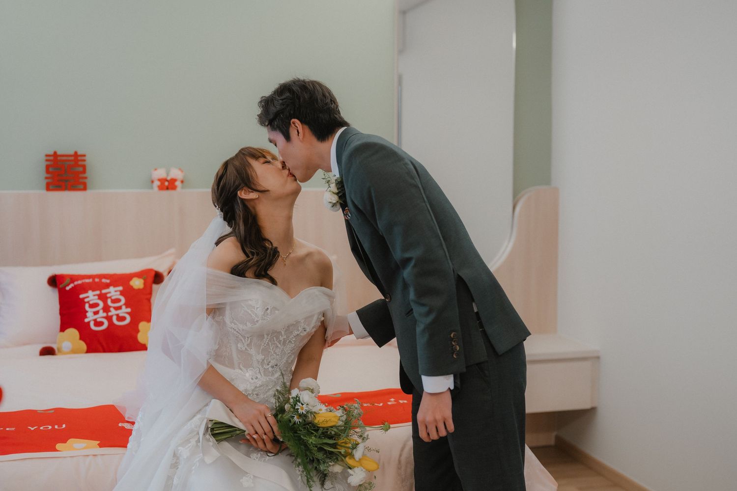 Newlyweds sharing intimate moments with traditional Chinese wedding elements.