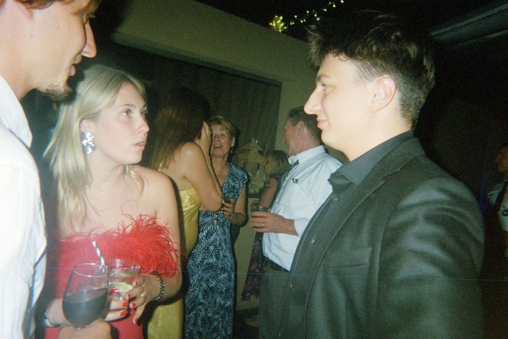 A series of four blurry candid party photos showing people dancing and socializing at a dimly lit event.
