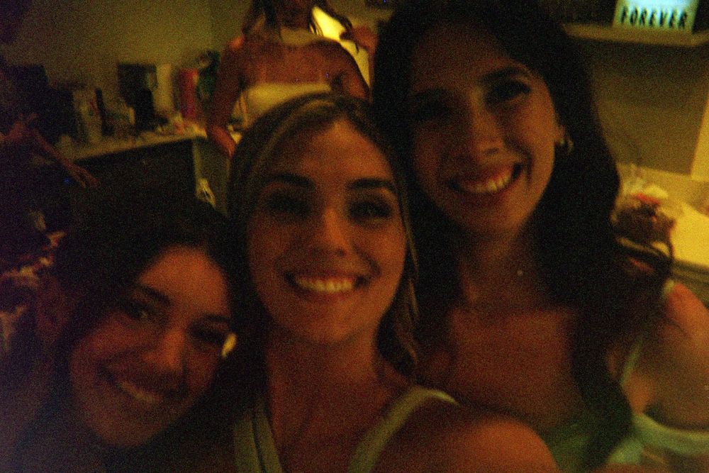 A series of dark indoor photos showing people in dimly lit settings looking at the camera and smiling.