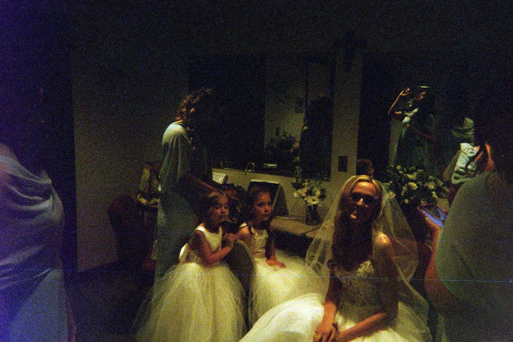 People gather in a dark room illuminated by spotlights during what appears to be a performance or event.