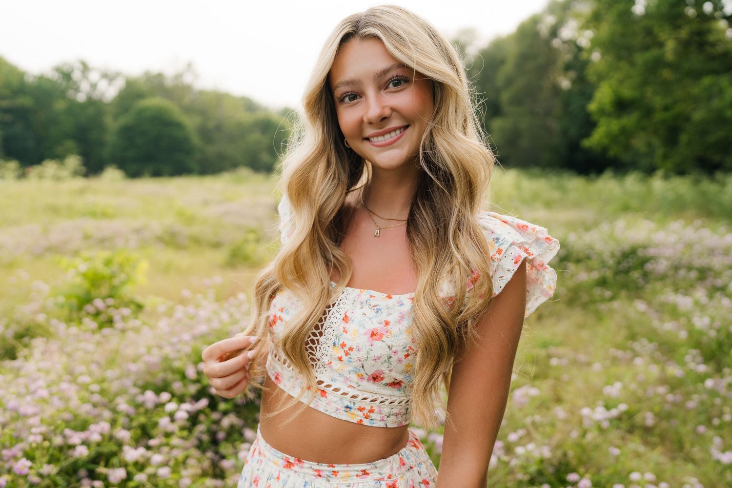 A floral dress photoshoot in a wildflower meadow with natural lighting and dreamy summer atmosphere.