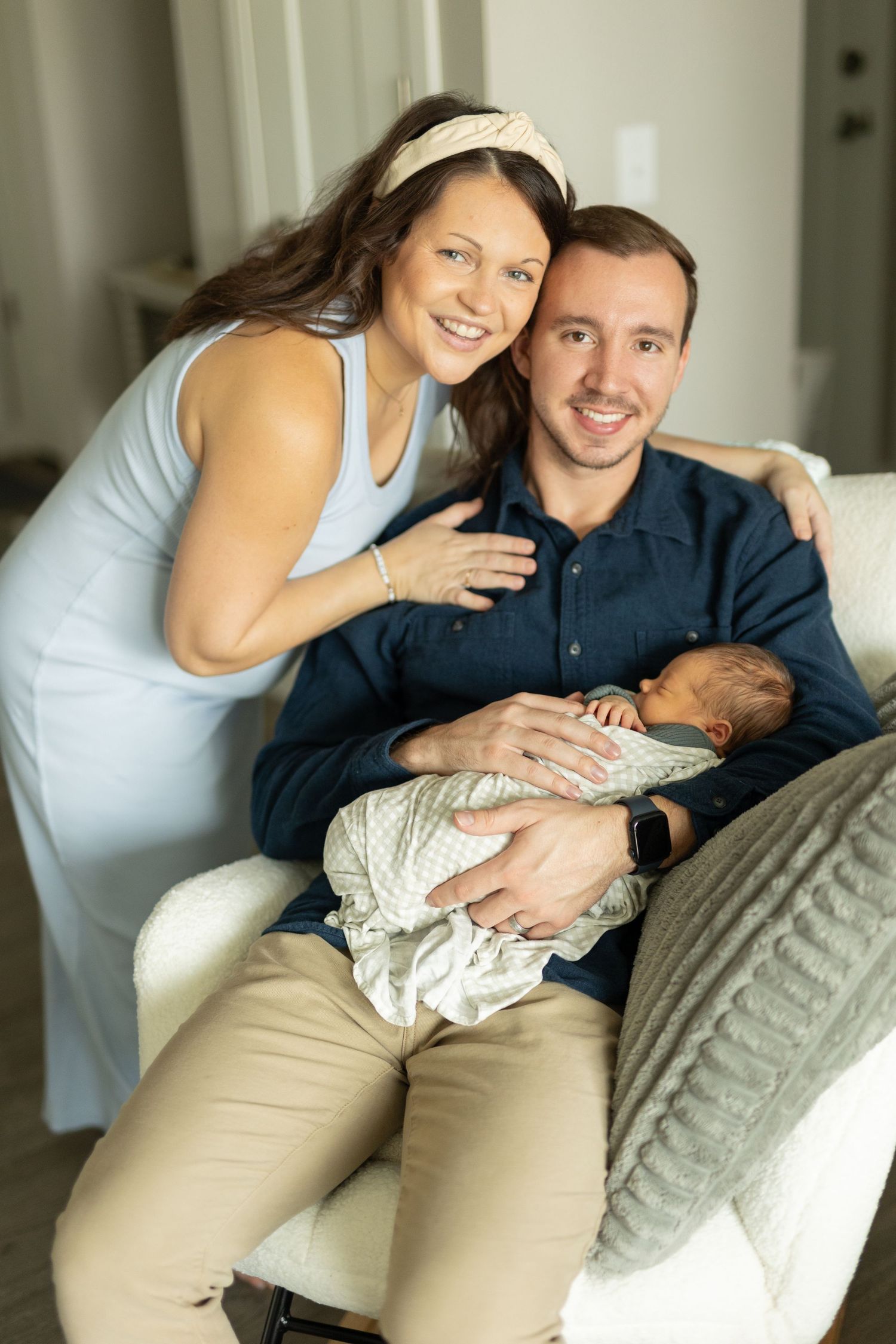 Smiling couple holding their newborn son