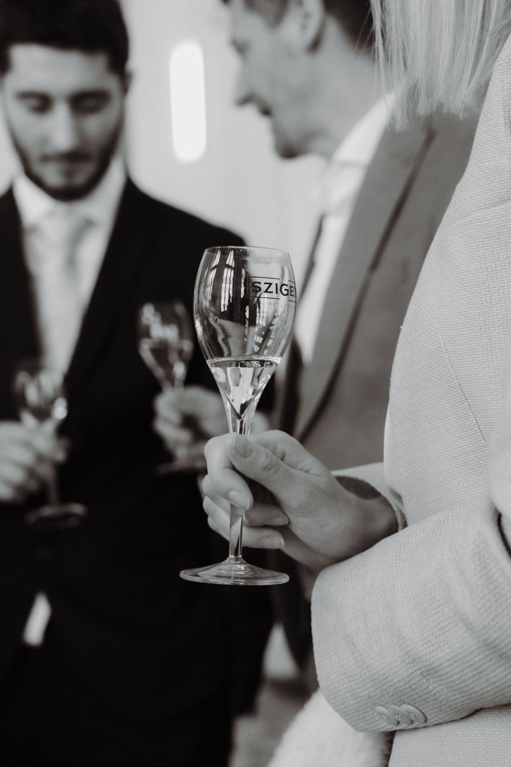schwarz-weiß Fotografie - offene Blende, viel Unschärfe - Sekt´-Glas ist im Fokus.