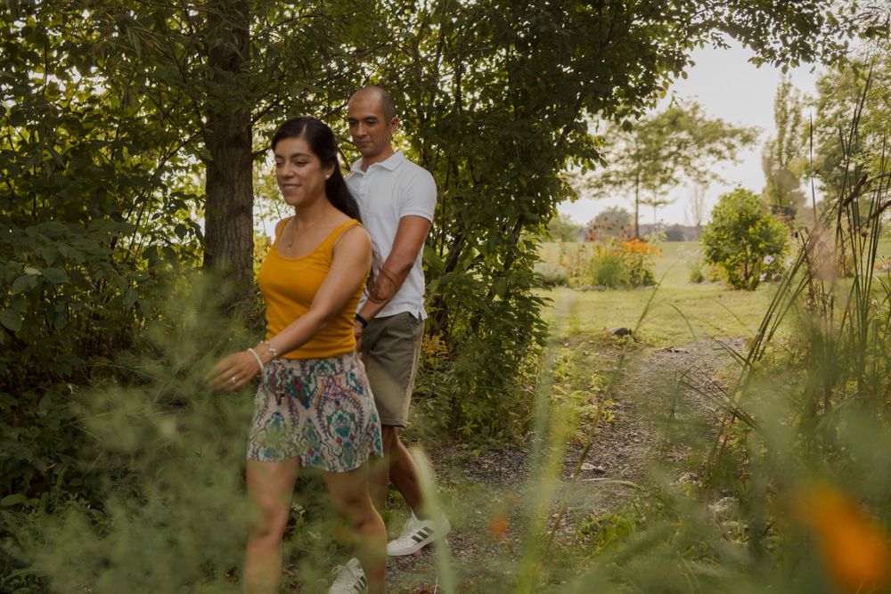 Couple walk through a path to the shoreline of Lake Ontario. Kingston, On, Ca