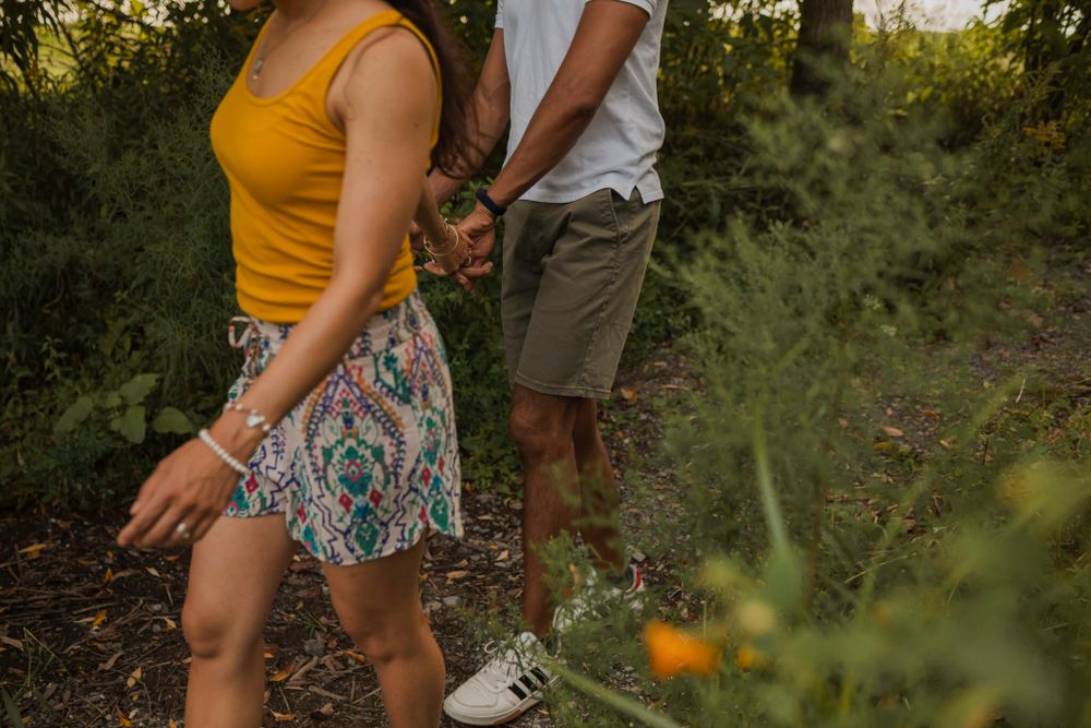 Couple walk through a path to the shoreline of Lake Ontario. Kingston, On, Ca