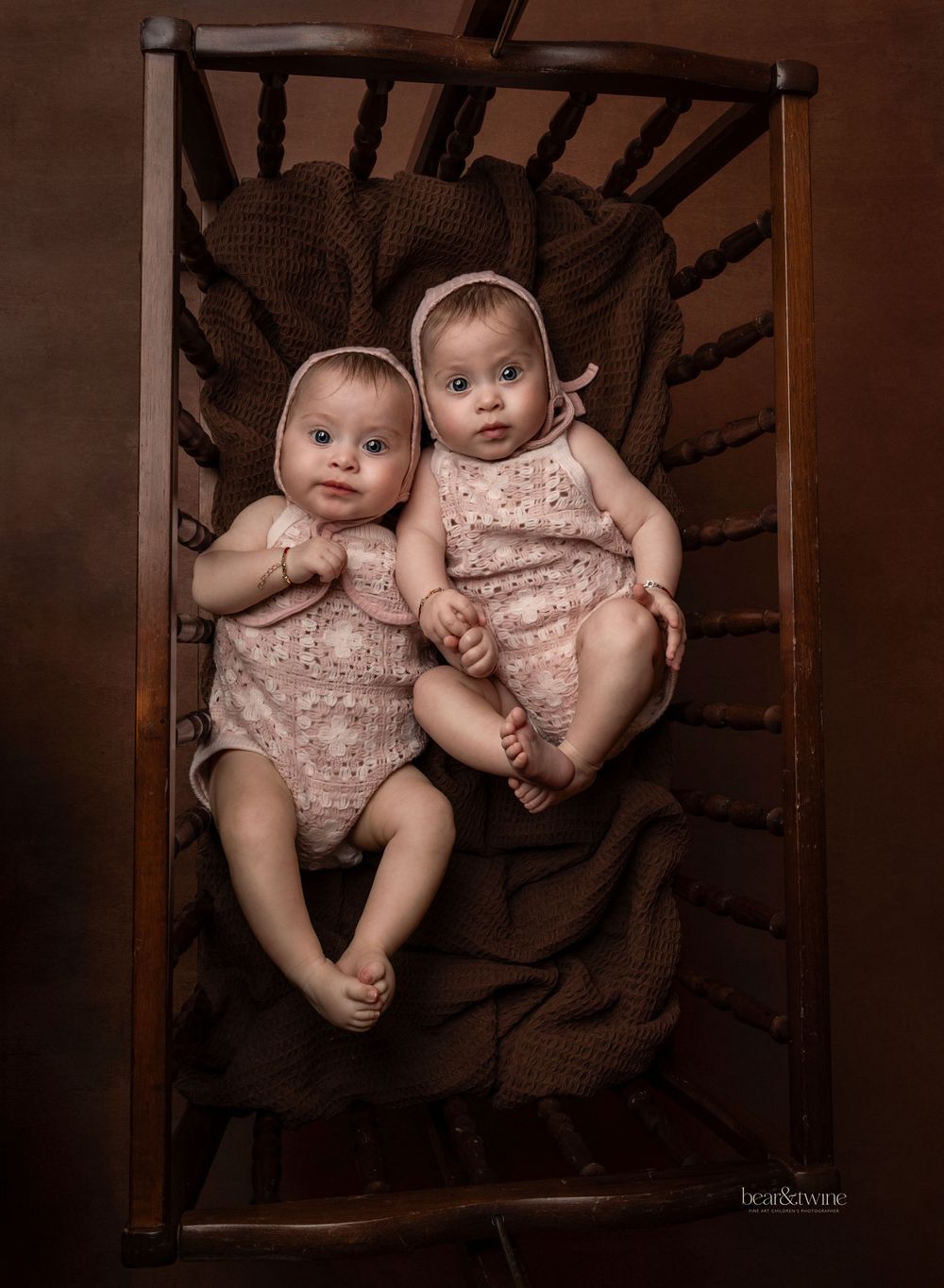 Twin babies lying in a vintage cot.