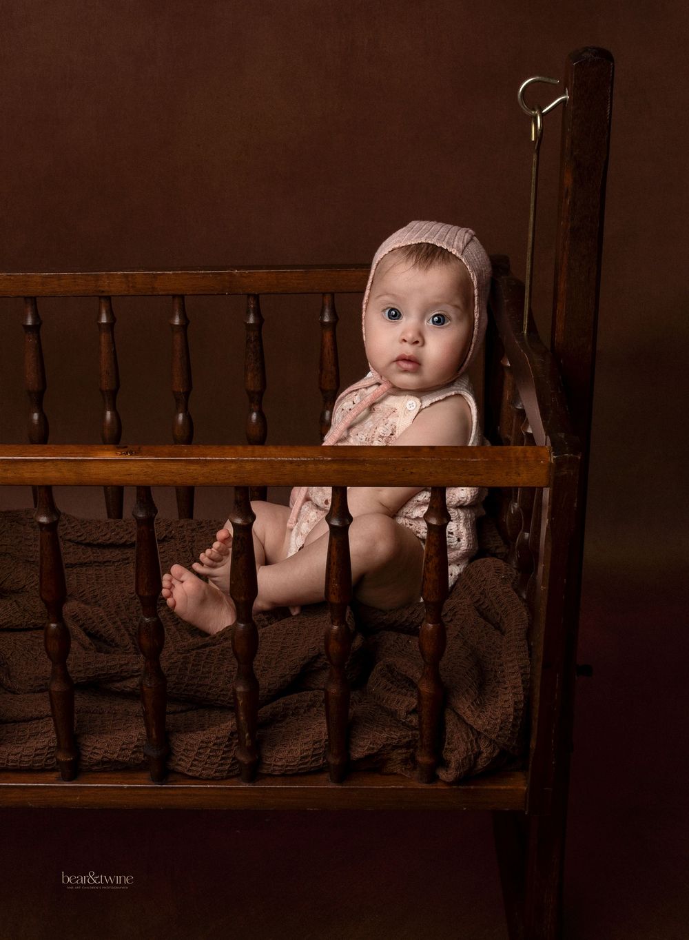 Fine art portrait of a  baby girl in a vintage cot.