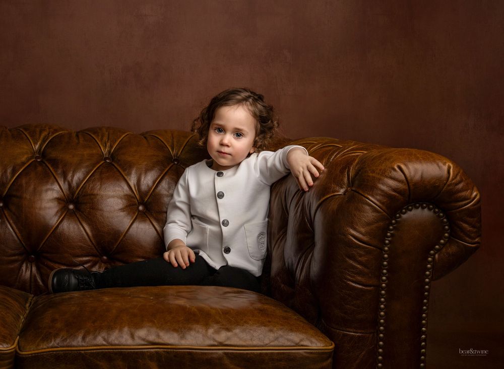 Fine art portrait of a boy on a vintage couch.