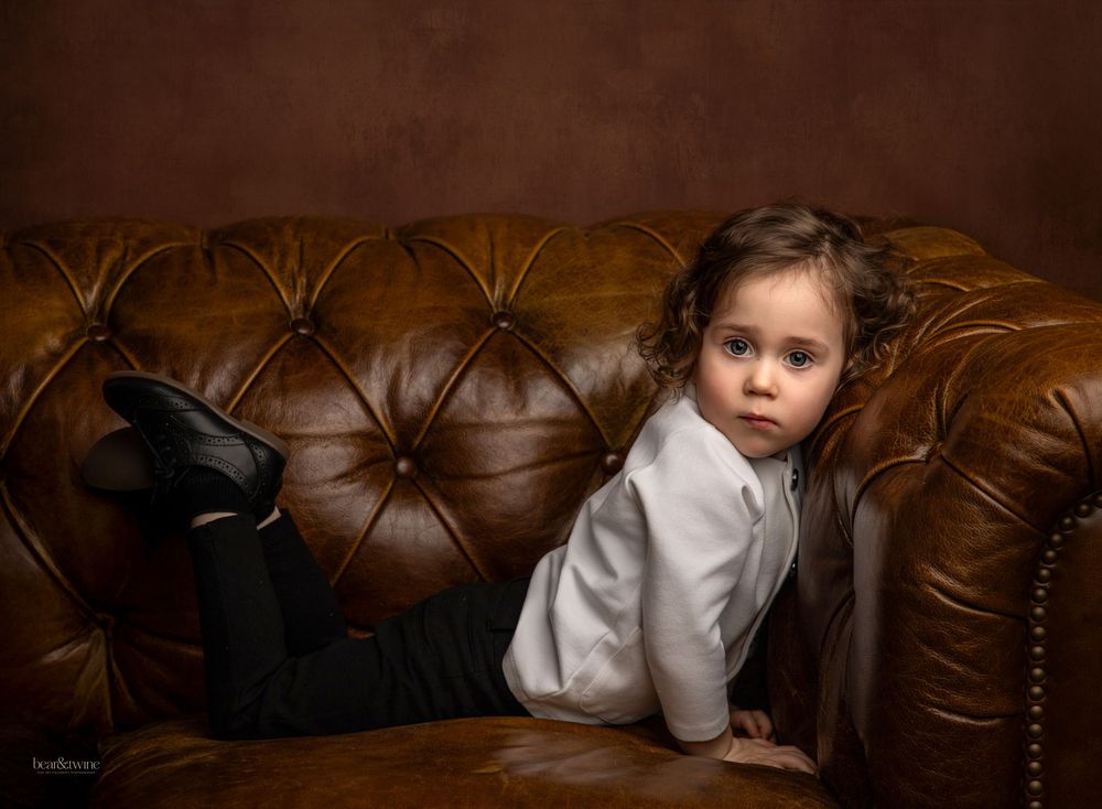 Fine art portrait of a boy on a vintage couch.