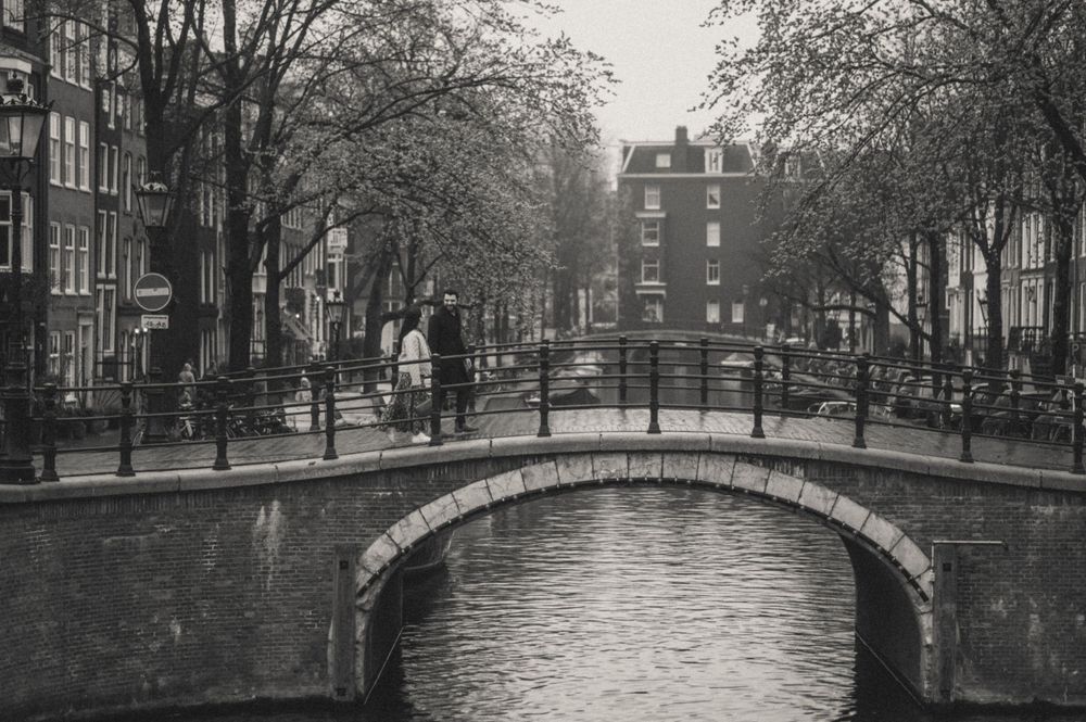 Historic canal bridges and buildings in Amsterdam on a cloudy winter day.