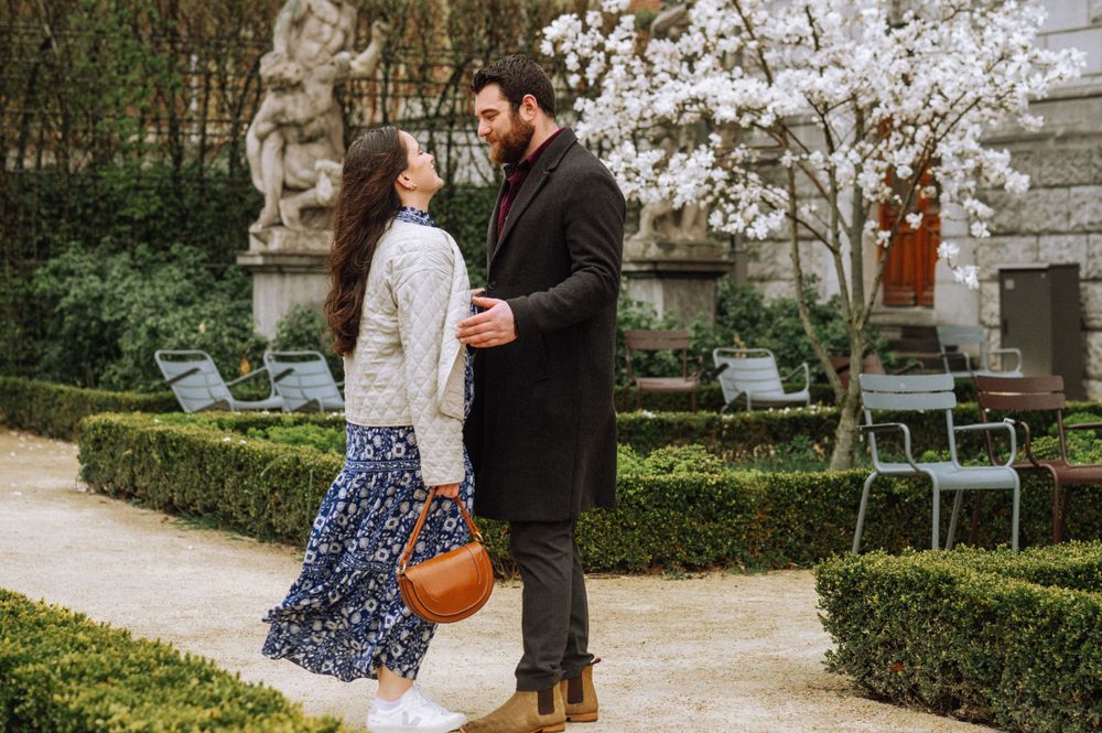 A romantic moment in a garden with blooming spring flowers and hedges.