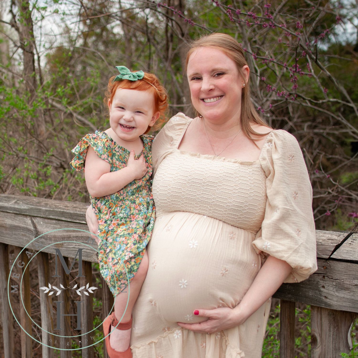 Photo of an expectant mom and her two year old daughter sharing a tender moment together  during springtime.