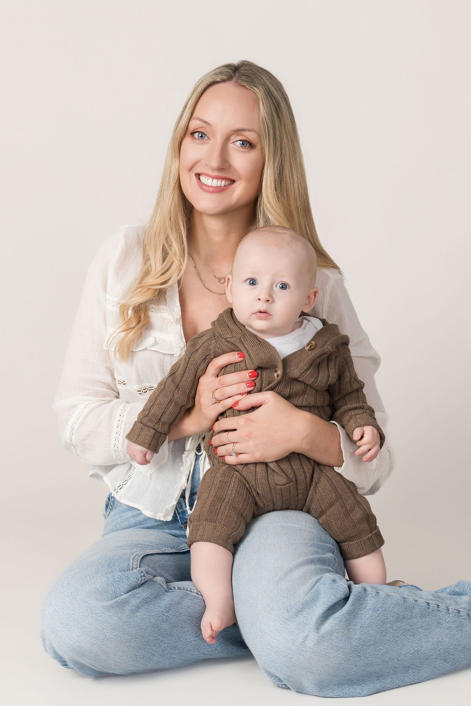 Studio portrait with white background showing tender moment between parent and baby.