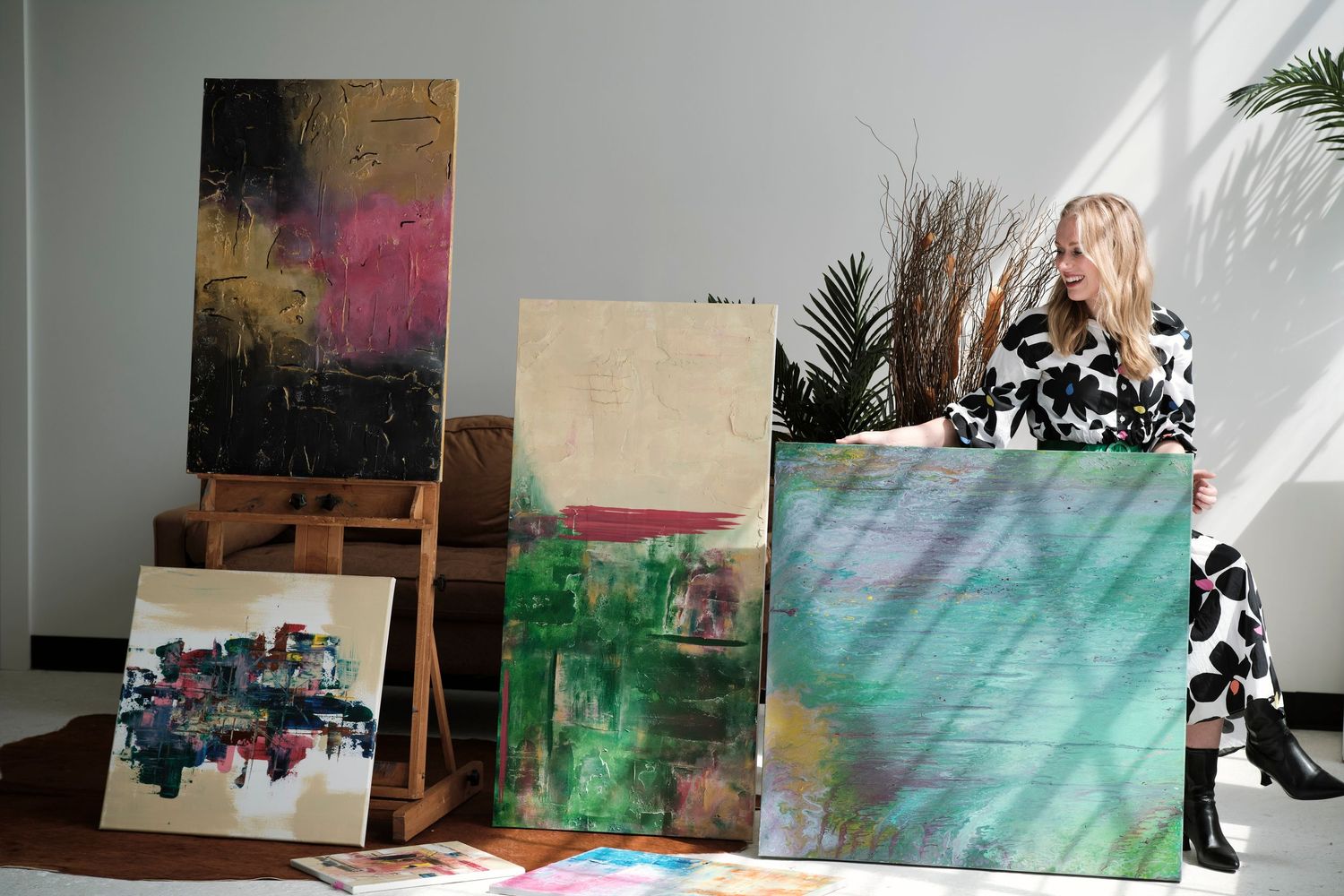 Abstract art pieces arranged in a gallery-like setting with colorful paintings and mixed media works displayed against walls.
