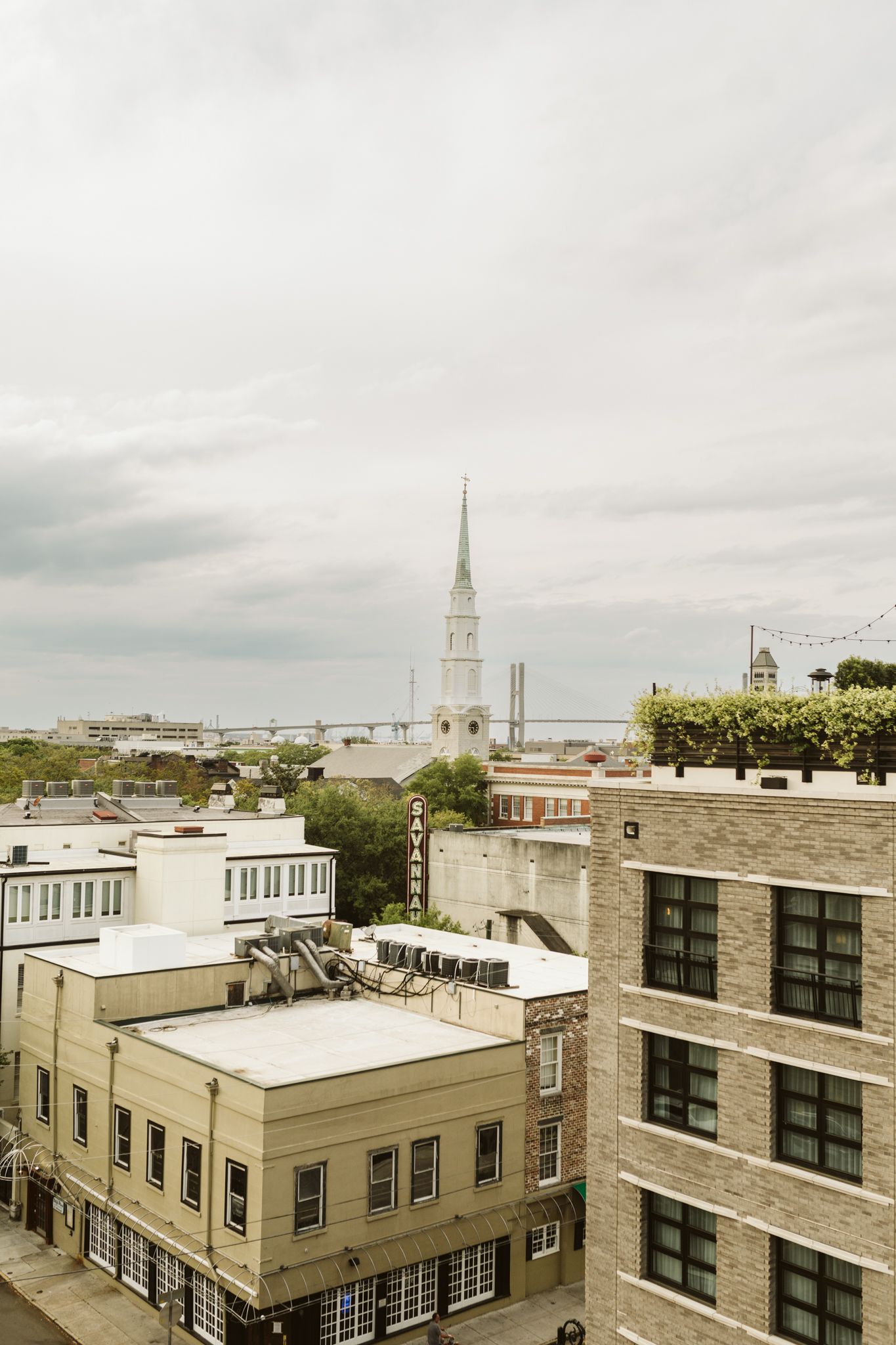 Aerial view of historic church steeples and rooftops in a New England town under cloudy skies.