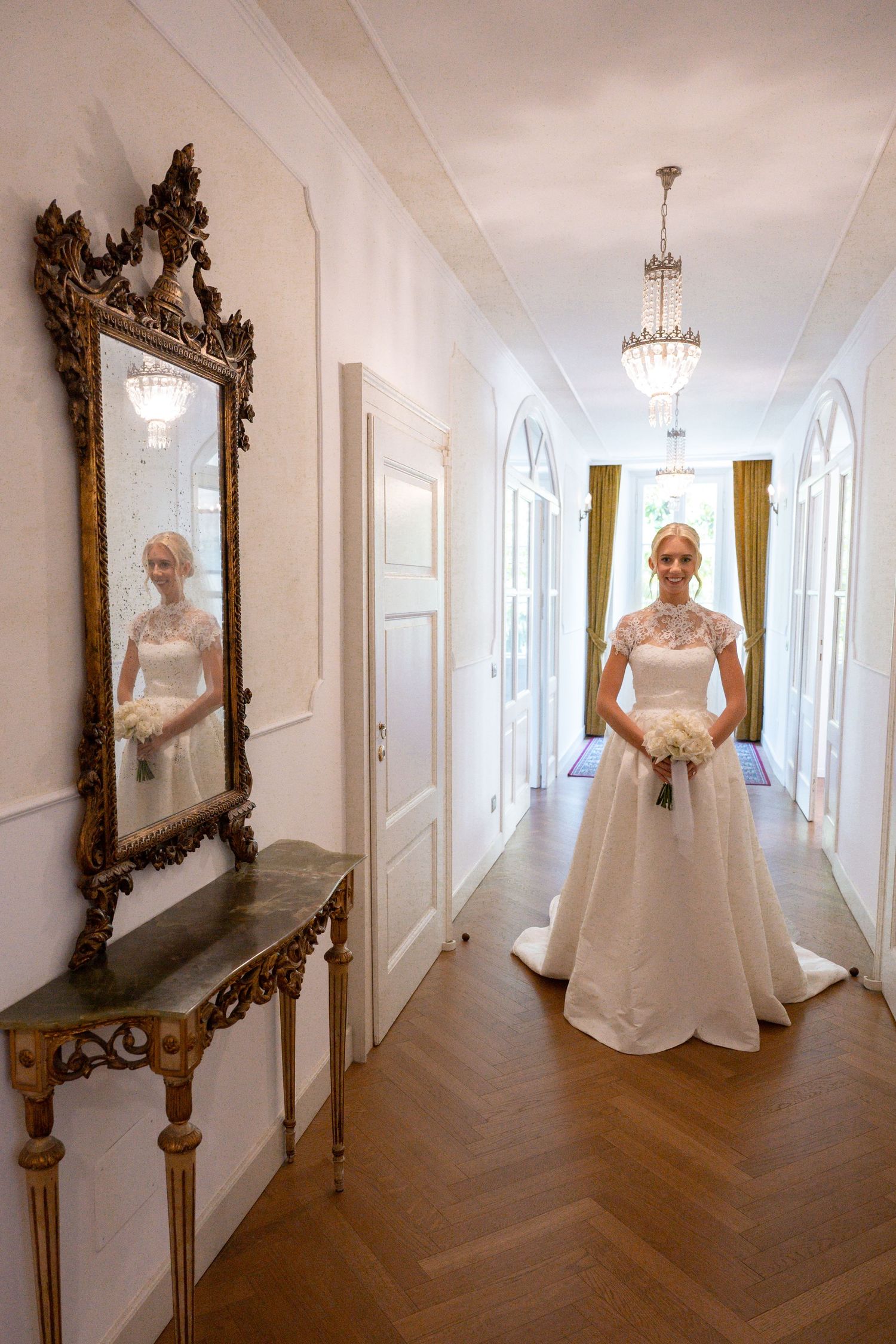 A series of elegant wedding dress photos in a bright white hallway with ornate gold-framed mirrors and hardwood floors.