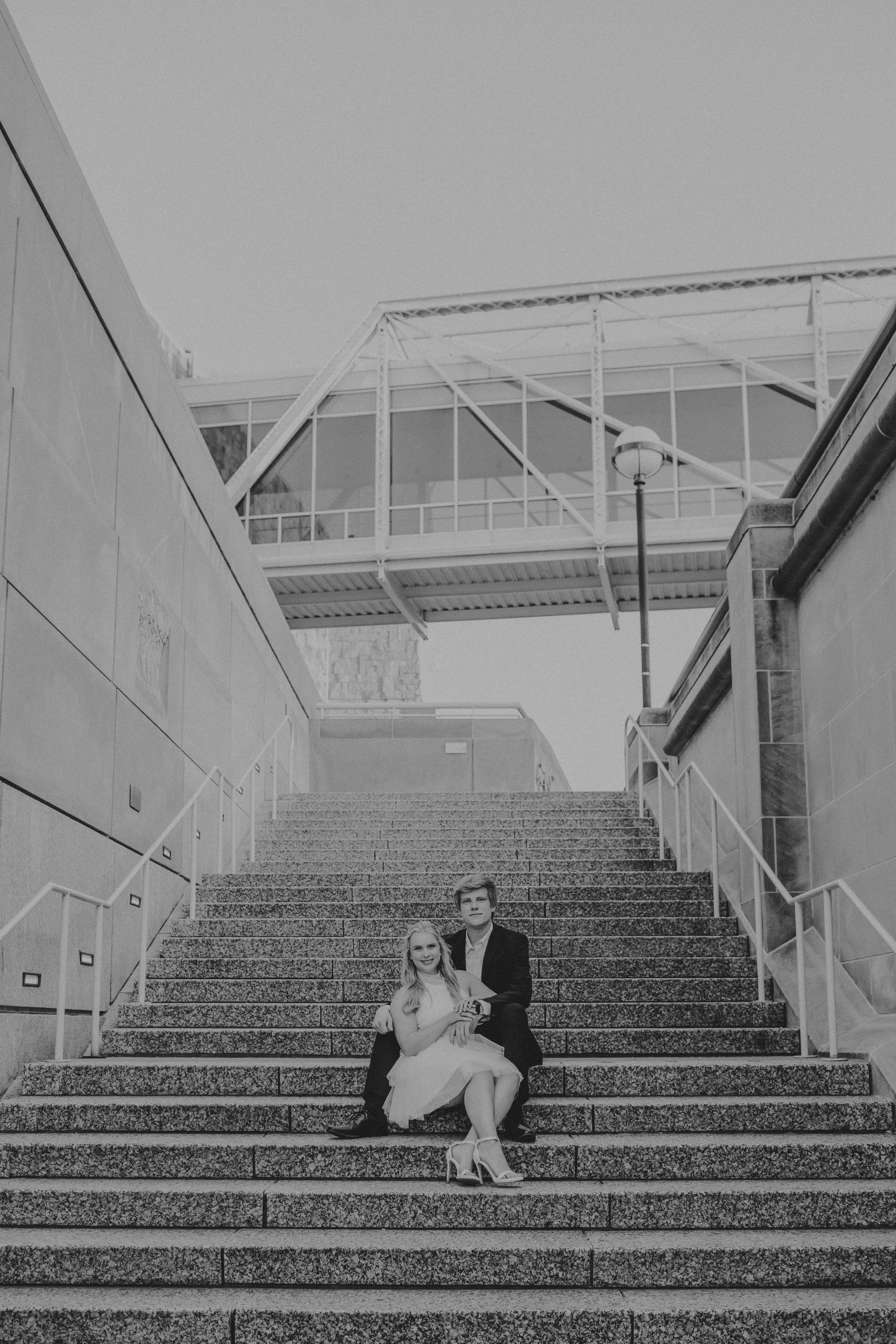 A sequence of black and white photos showing a couple sitting on stone steps in various poses.