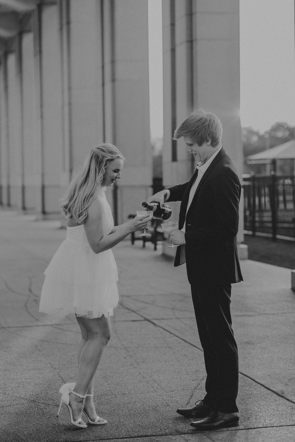 Black and white photo series showing a romantic proposal moment between two people on a walkway.