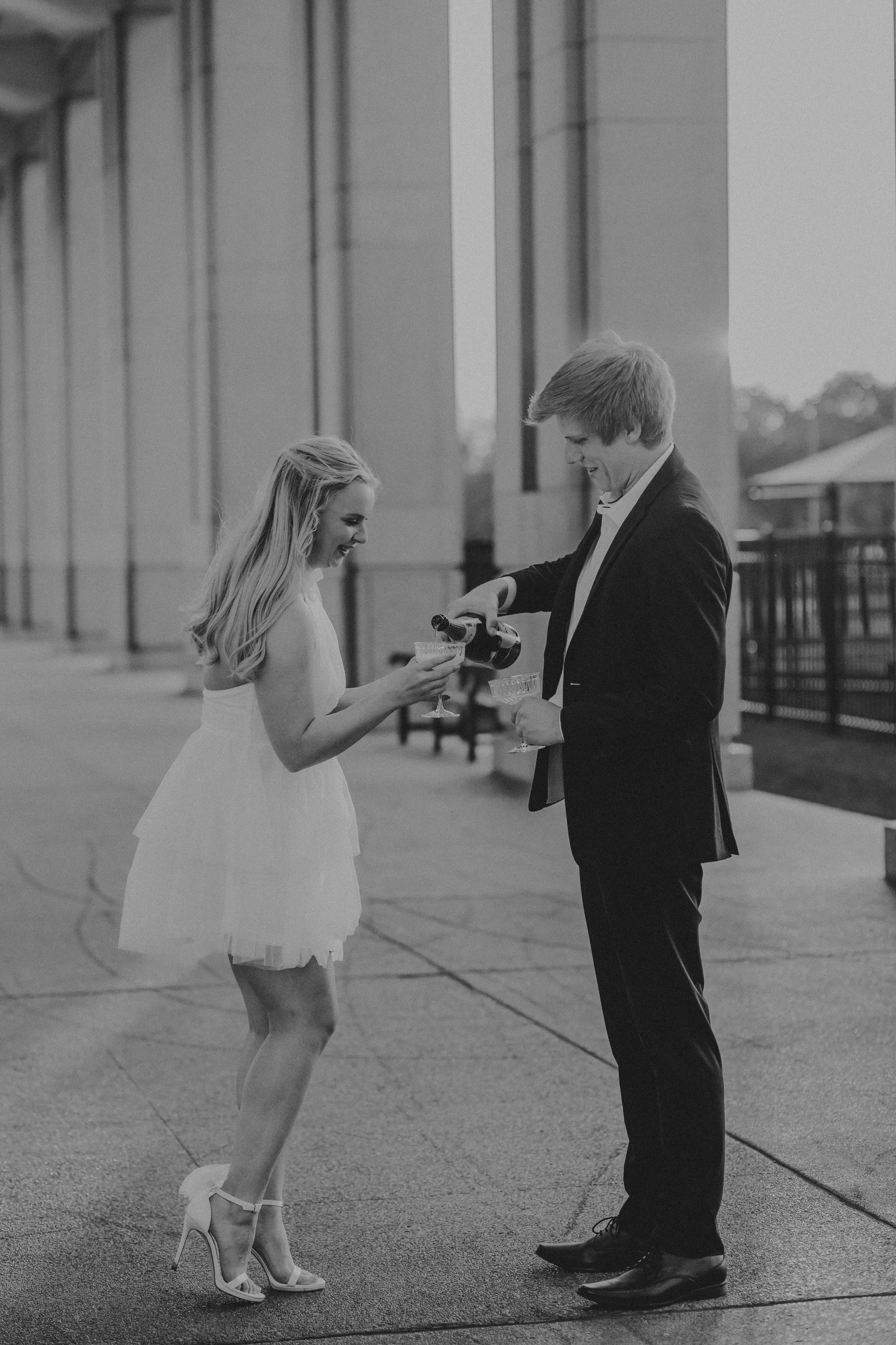 Black and white photo series showing a romantic proposal moment between two people on a walkway.