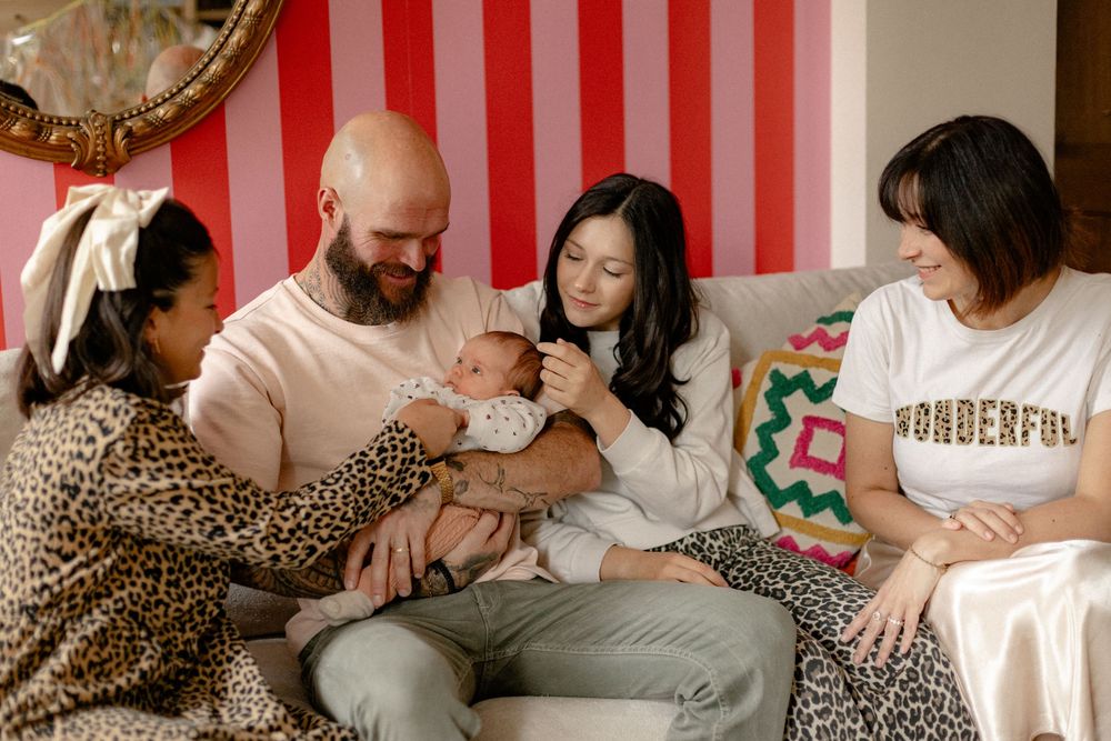 A series of intimate family moments captured in a photo collage with leopard print and striped decor elements.
