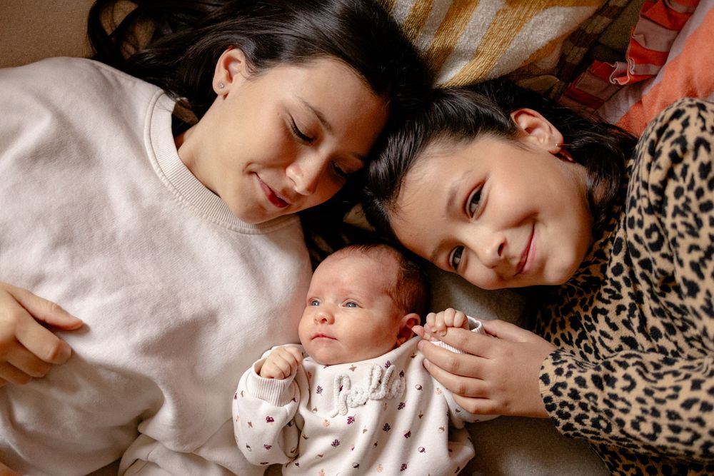 Family members lying together on leopard print bedding sharing intimate moments and cuddles.