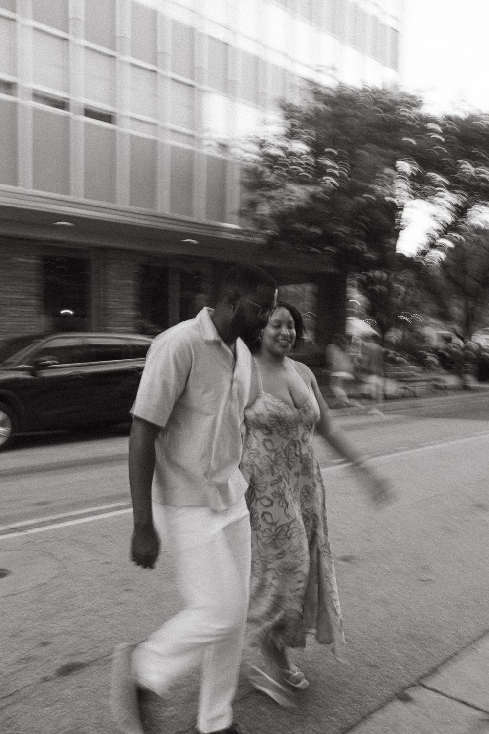 Black and white sequence of motion blur photos showing two people walking together on a city sidewalk.