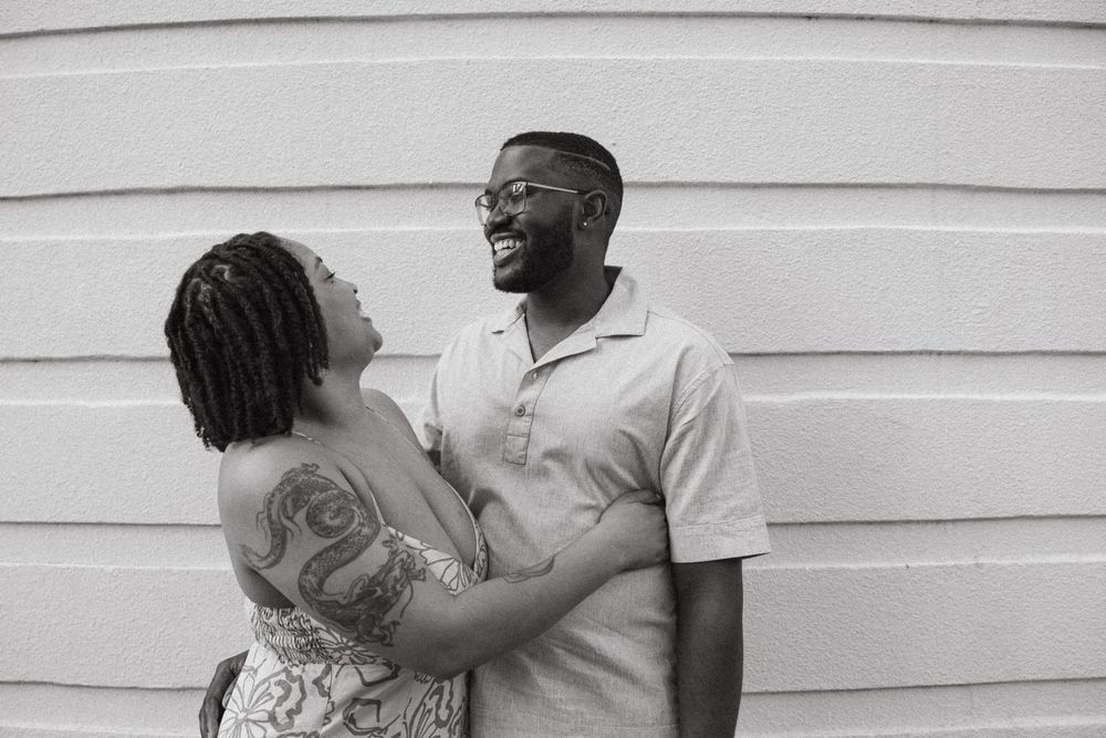 A black and white photo sequence showing a couple embracing and dancing together against a white wall.