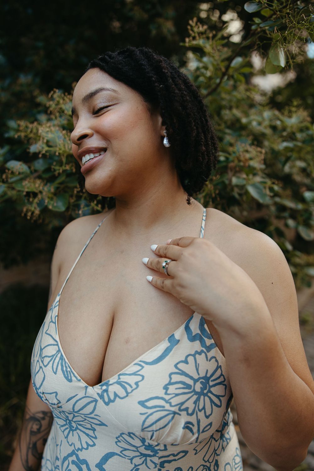 A floral blue and white dress detail is shown against a natural green background.