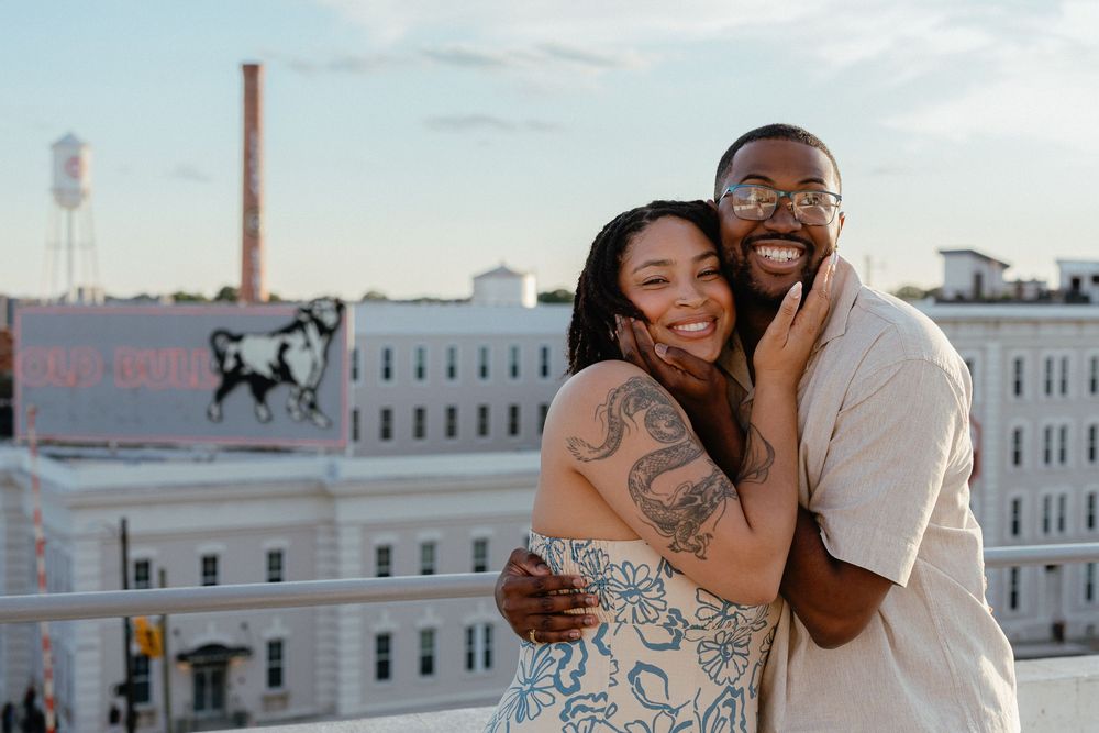 A couple shares tender moments together on a rooftop during a romantic urban photoshoot at sunset.