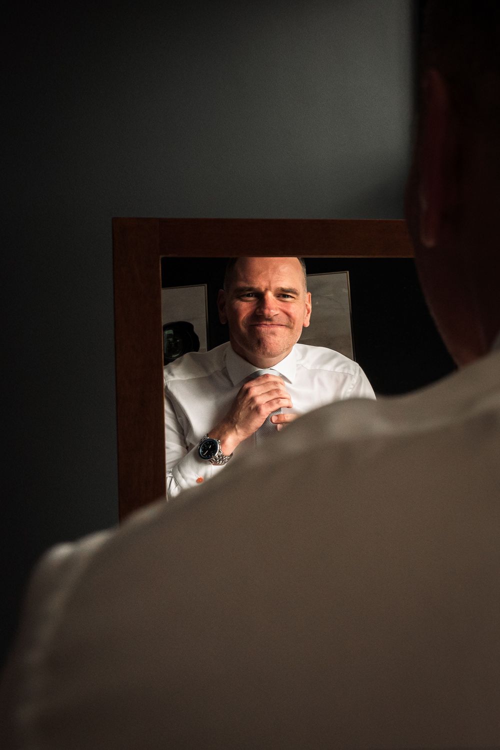 A series of close-up shots showing a man's reflection in a mirror while getting ready.