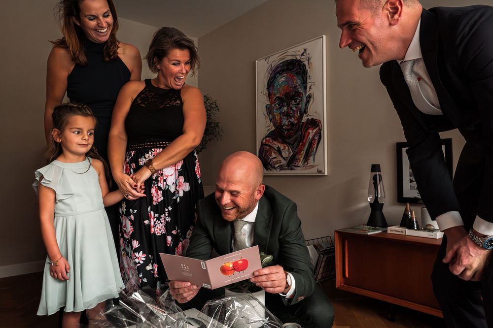 Family members gather around a table during an intimate indoor celebration.
