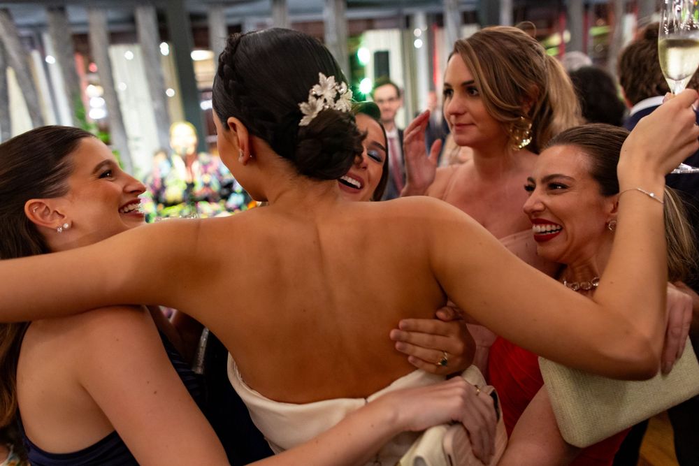 Wedding guests dance and celebrate together on a crowded dance floor at a reception party.