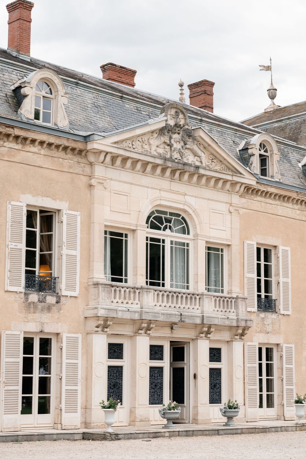 Elegant French chateau facade with classic architecture featuring tall windows and decorative stone details.