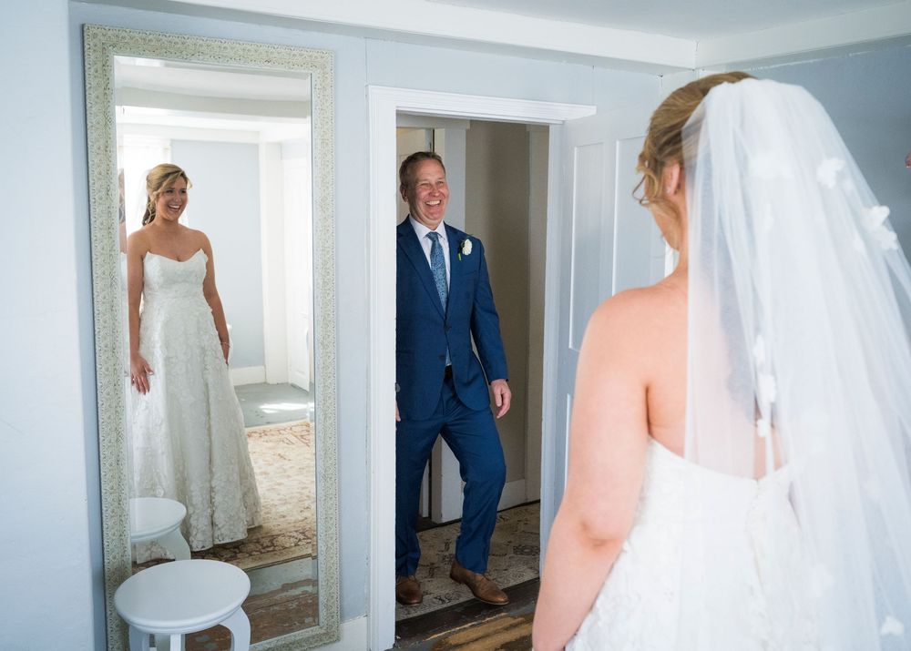 Groom smiles as he sees his bride for the first time in a romantic wedding day first look moment.