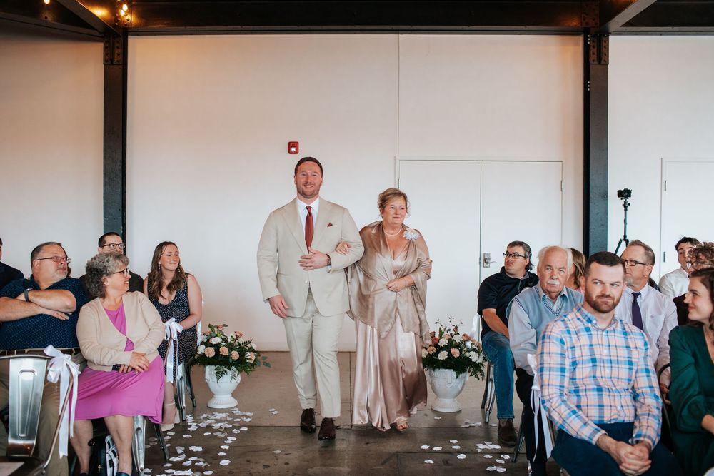 Wedding guests share joyful reactions and laughter during a reception celebration.
