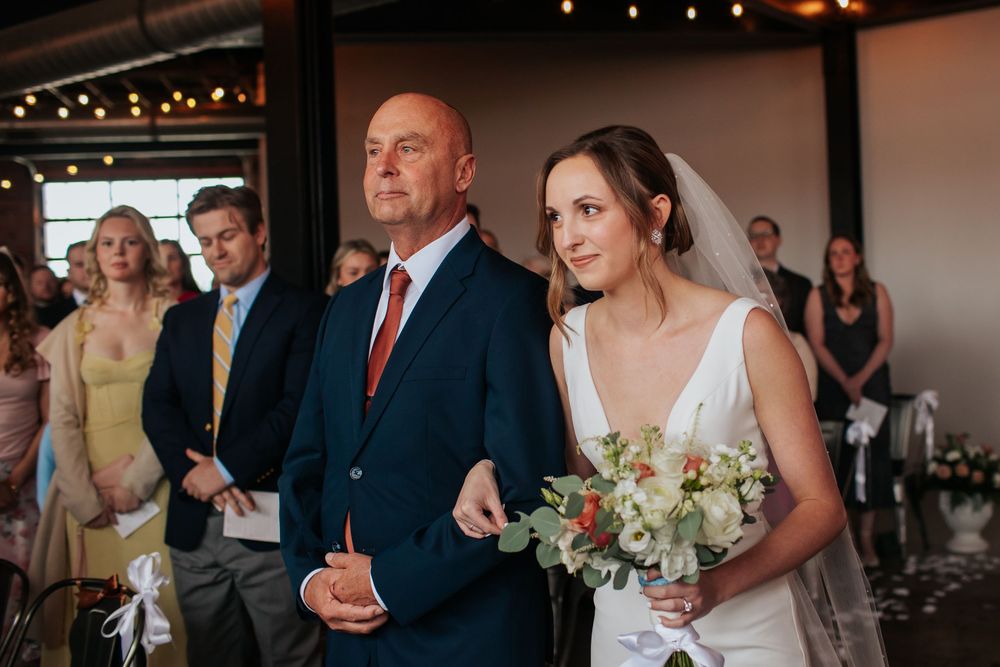 A wedding reception venue decorated with string lights and guests dancing and mingling on the dance floor.
