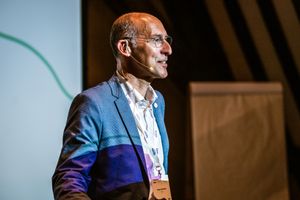CEO Liantis met een headsetmicrofoon en naamkaartje presenteert vol enthousiasme tijdens een Liantis Event.