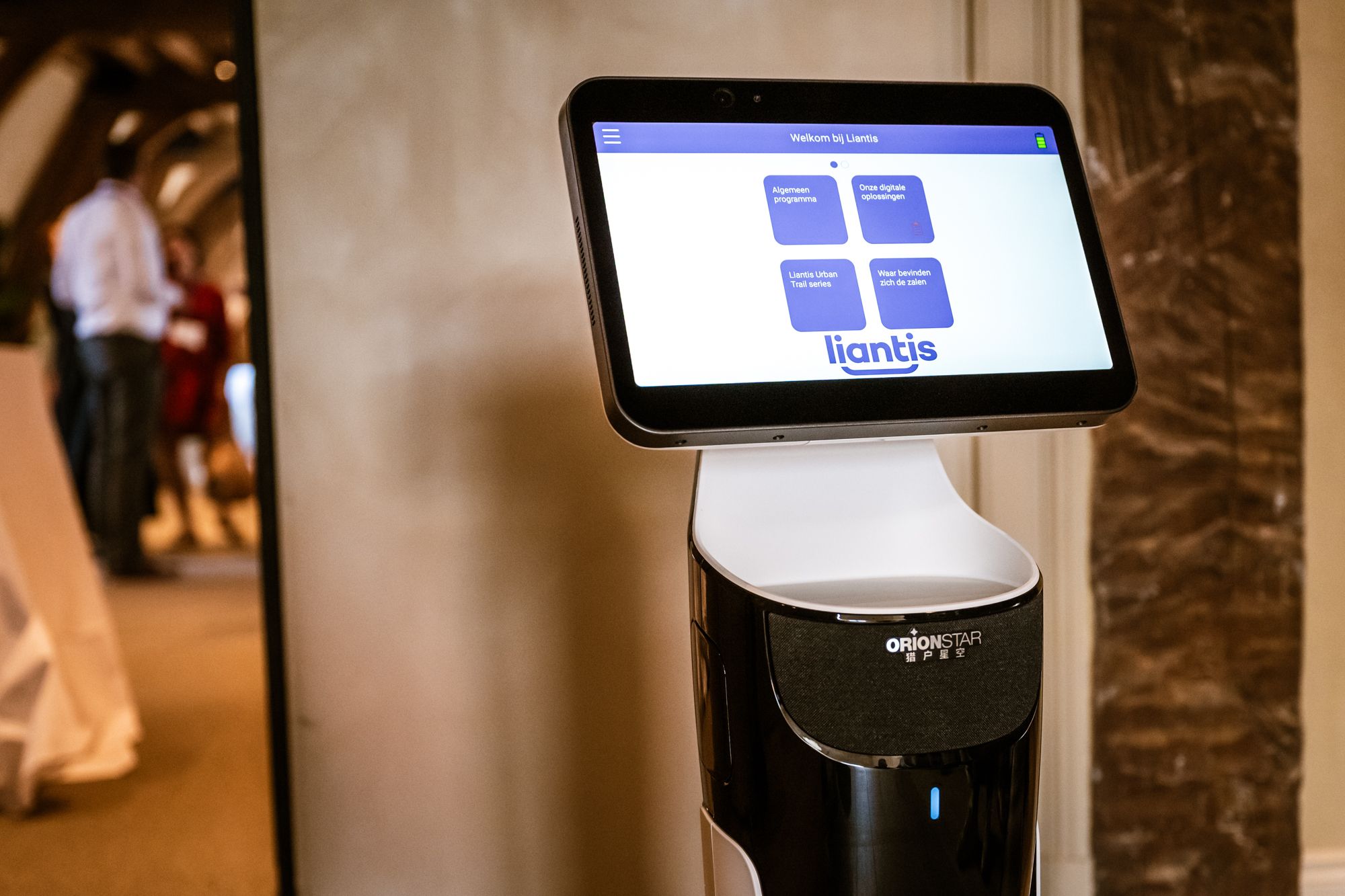 Een robot met een interactief scherm toont het logo van Liantis en biedt opties zoals digitale oplossingen