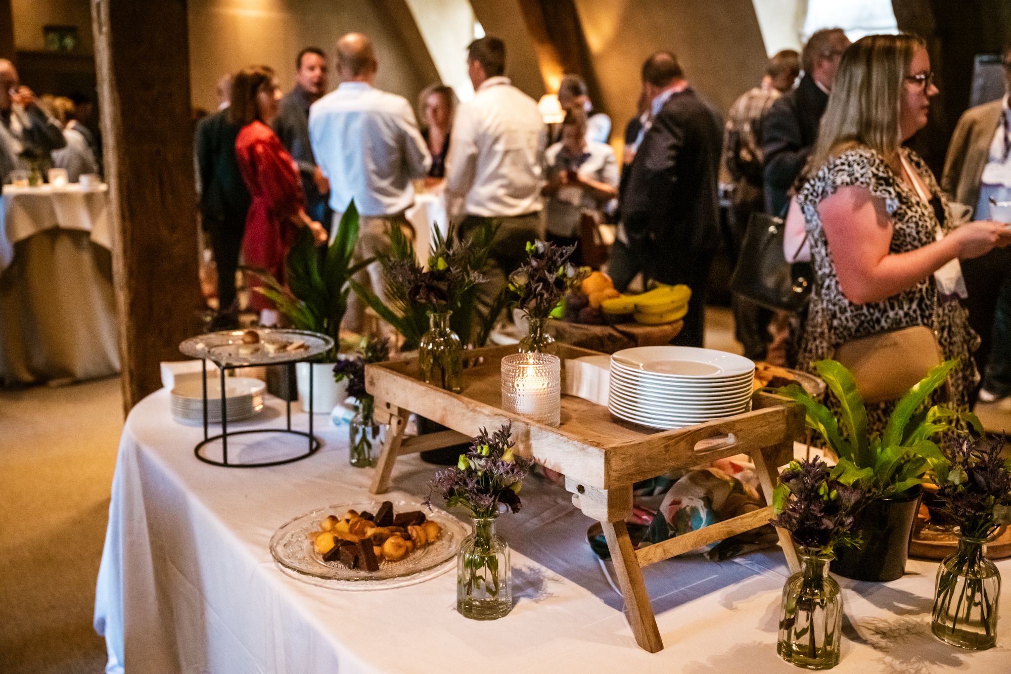 Een sfeervolle tafel met gebak, servies en bloemen in een gezellige setting tijdens een Liantis Event